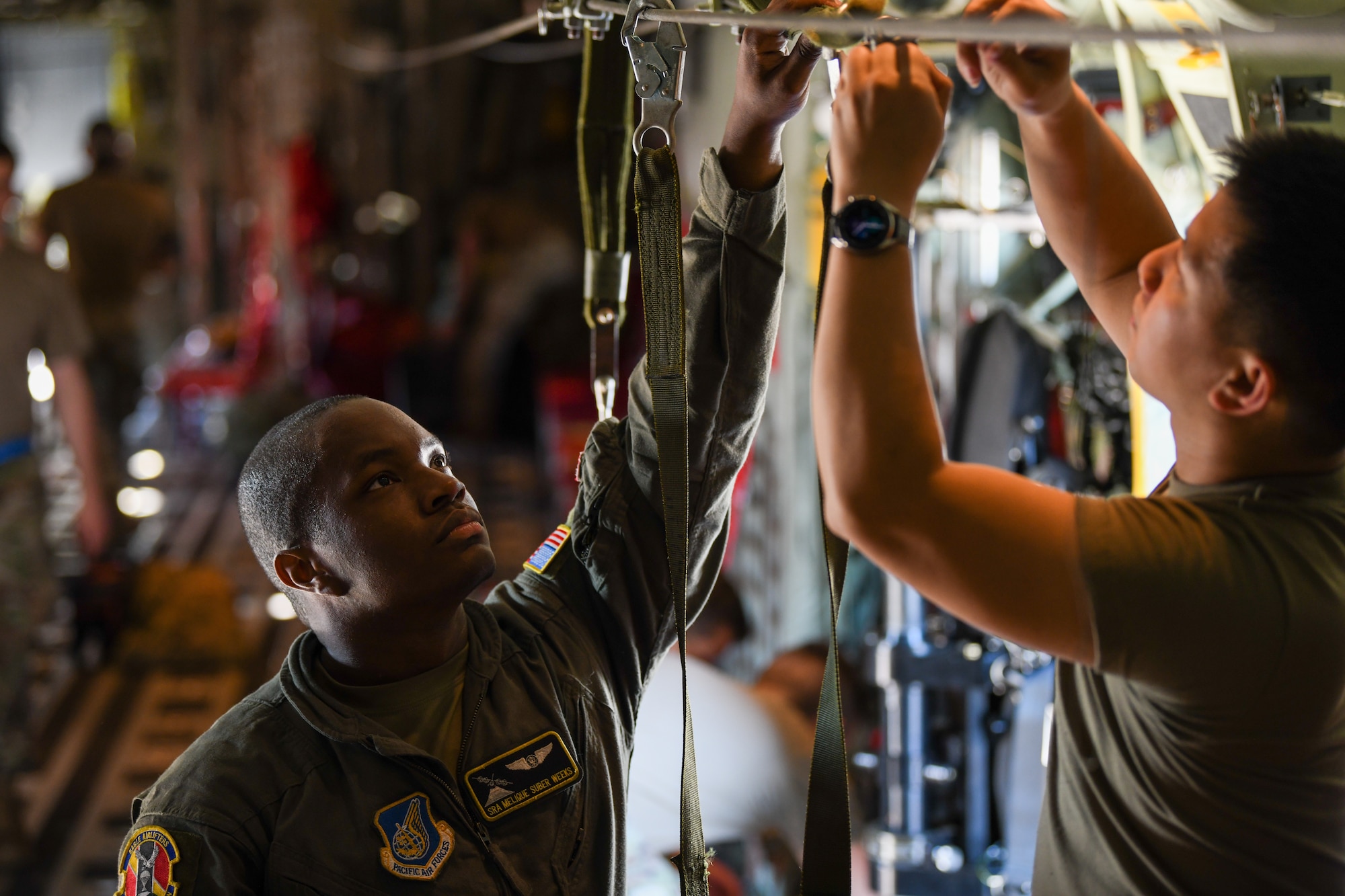 Loadmasters adjust static lines in a C-130J