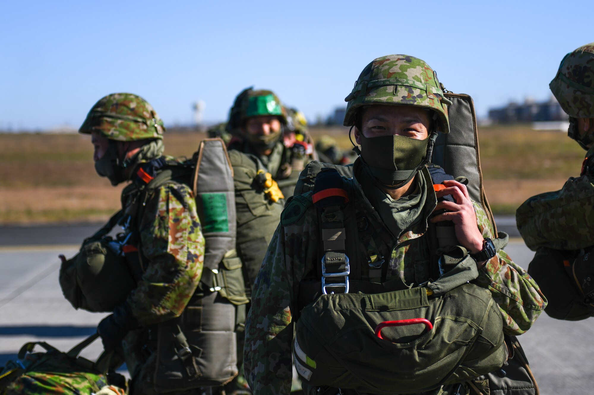 A Japan Ground Self-Defense Force soldier smiles before boarding a C-130J