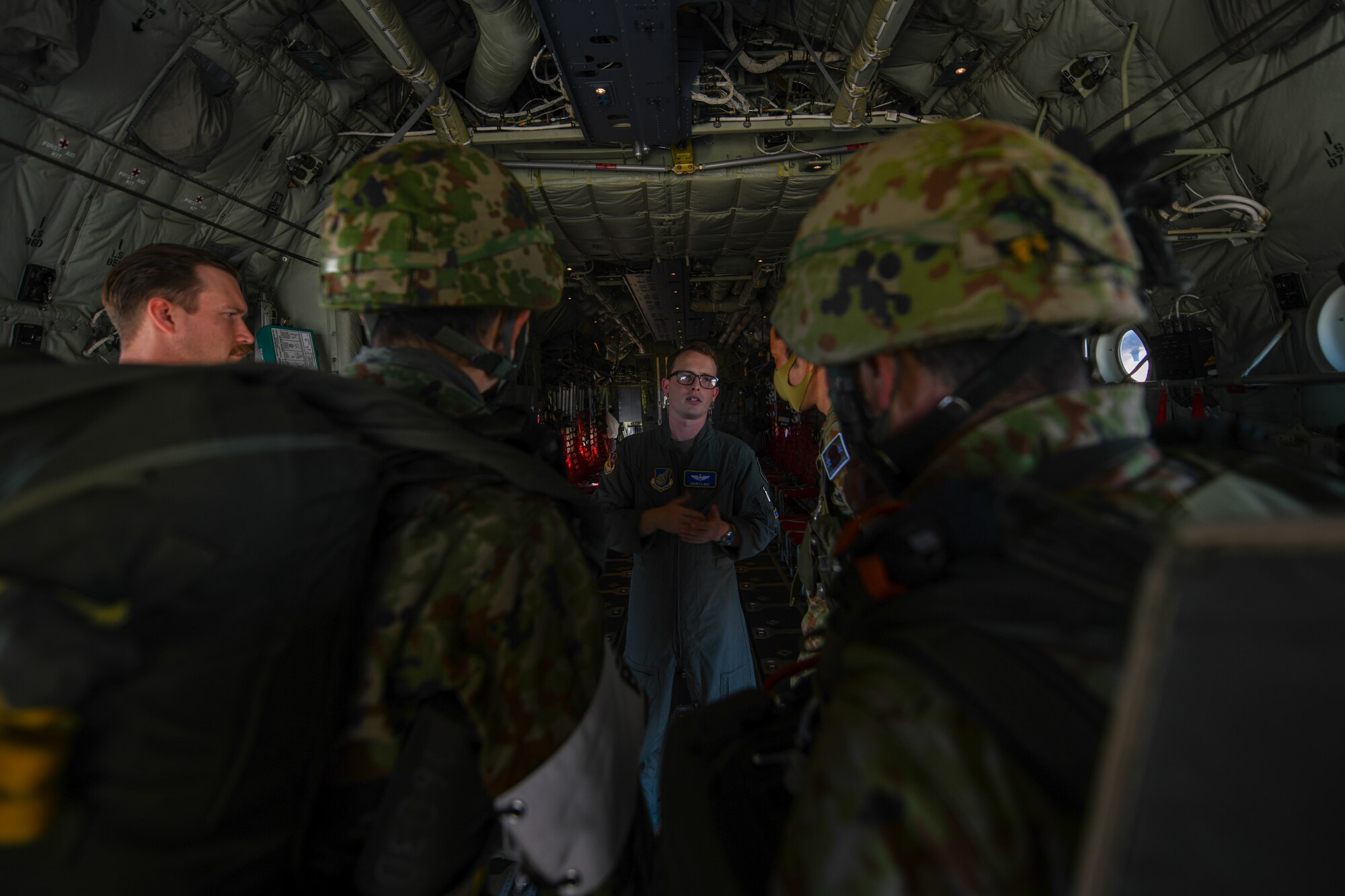 A C-130J instructor pilot briefs Japan Ground Self-Defense Force jumpmasters inside a C-130J