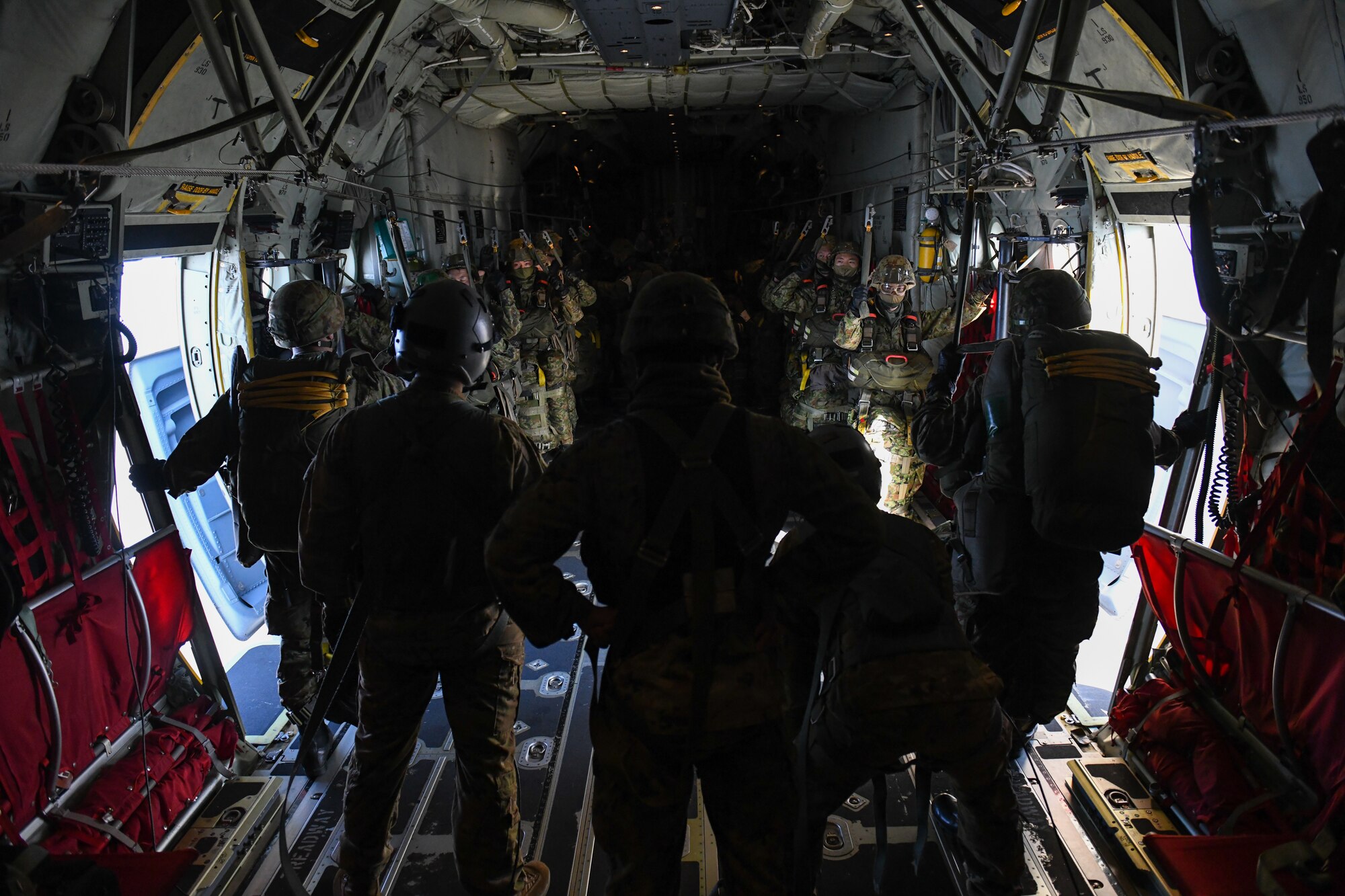 Japan Ground Self-Defense Force jumpmasters prepare to jump from a C-130J