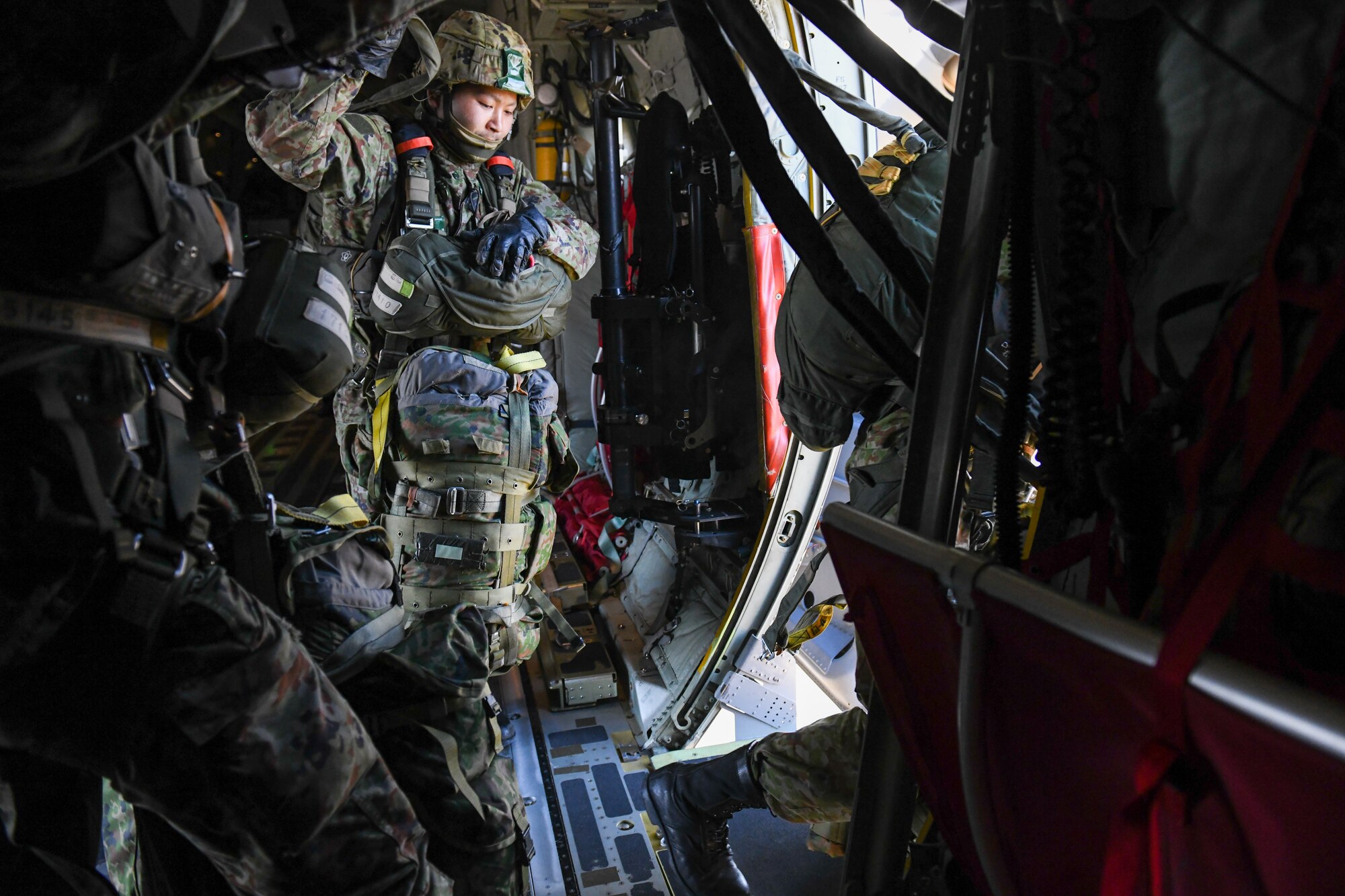 A Japan Ground Self-Defense Force soldier jumps from a C-130J