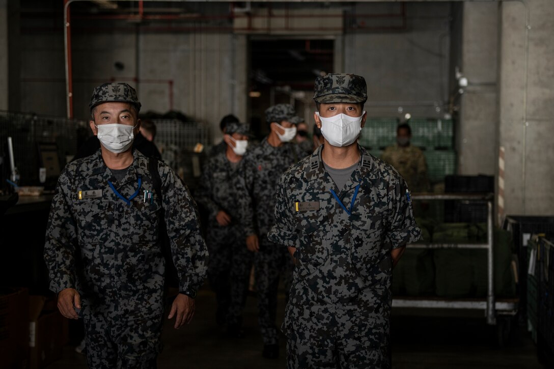 Japan Air Self-Defense Force Lt. Col. Sunao Matsumoto, right, 9th Air Wing base supply commander, and other JASDF members tour the 18th Logistics Readiness Squadron mobility processing building at Kadena Air Base, Japan, Nov. 10, 2021. Sharing practices and training tools strengthens relations between U.S. forces and host nation allies, creating a more effective bilateral partnership. (U.S. Air Force photo by Senior Airman Jessi Monte)