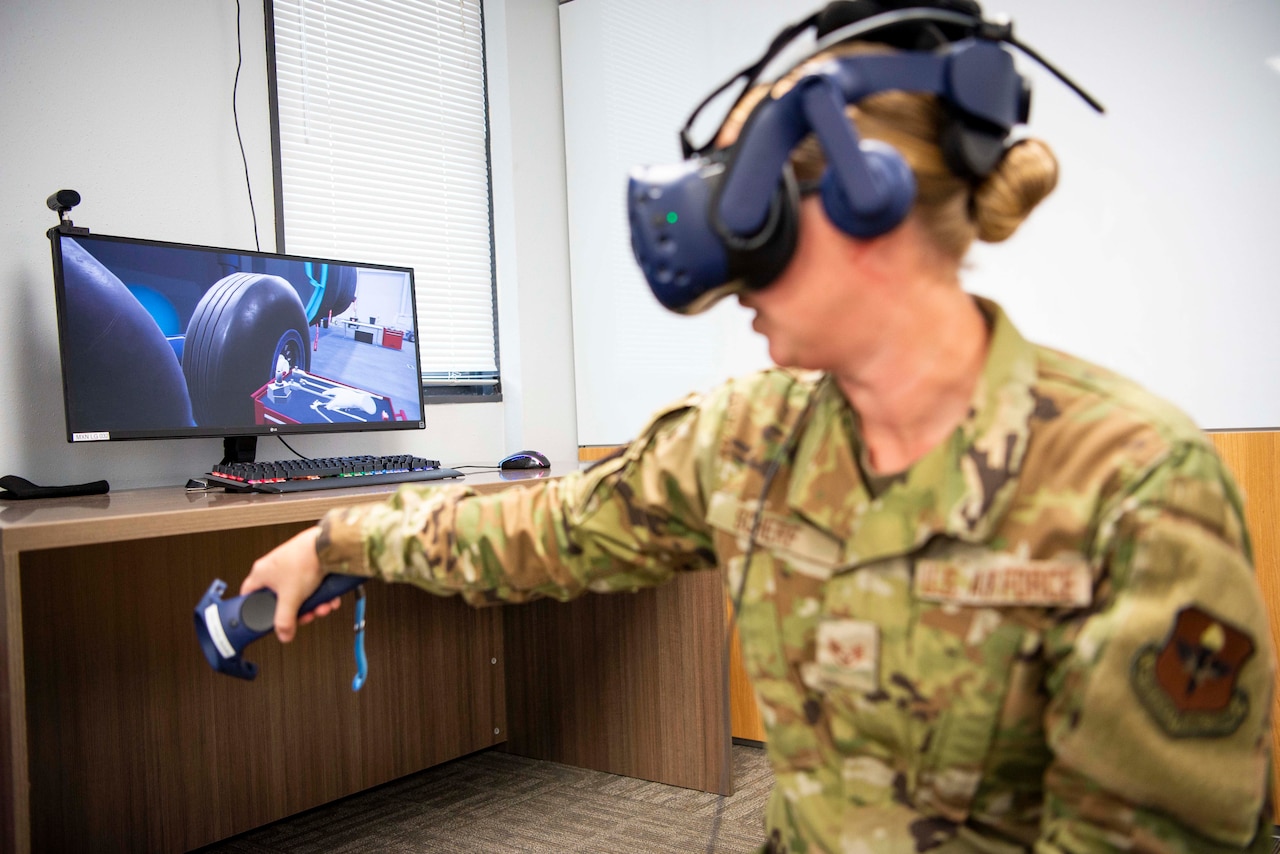An airman looks through a virtual reality lens.