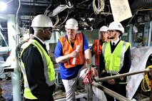 The Hon. Rupert Soames, OBE, and Cmdr. Brian Anthony, commanding officer, USS Winston S. Churchill, discuss the future layout of the pilot house with the ship’s navigator Lt. Cameron Fisher, Royal Navy, and Vince Stammetti, SERCO’s Senior Vice President, Maritime Engineering, Technology and Sustainment Business Unit.