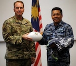 Washington Air National Guard Brig. Gen. Johan Deutscher presents a custom football to Maj. Gen. Dato Zulkifli, assistant chief of staff for operations and strategy for the Royal Malaysian Air Force and lead Malaysian delegate, during closing ceremonies of the fourth Airmen-to-Airmen talks at Camp Murray, Washington, Nov. 17, 2021. Washington and Malaysia have been partners through the State Partnership Program since 2017.