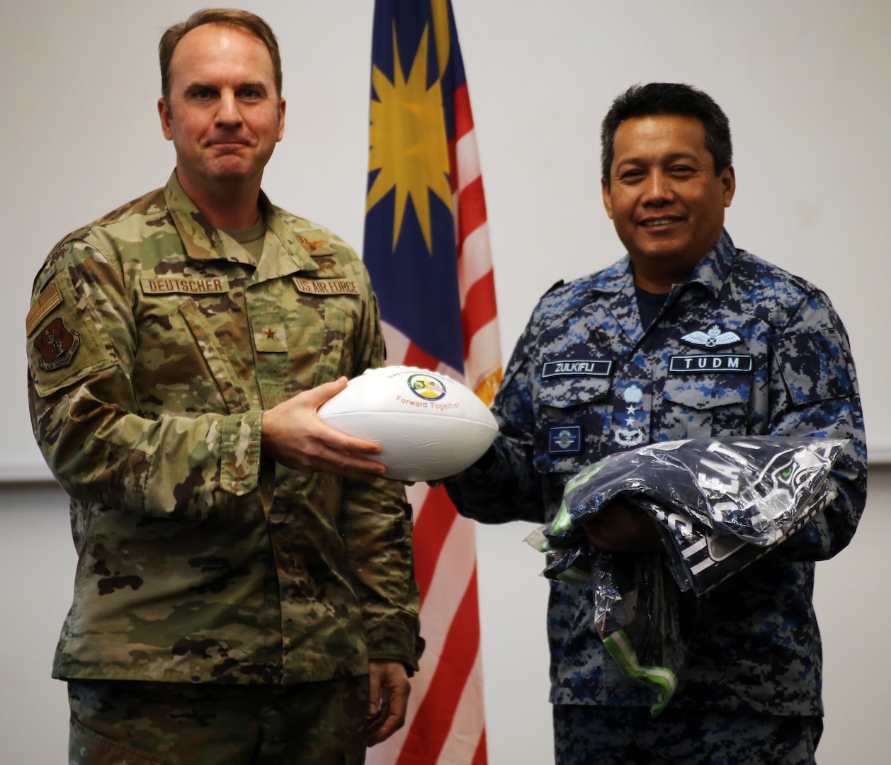 Washington Air National Guard Brig. Gen. Johan Deutscher presents a custom football to Maj. Gen. Dato Zulkifli, assistant chief of staff for operations and strategy for the Royal Malaysian Air Force and lead Malaysian delegate, during closing ceremonies of the fourth Airmen-to-Airmen talks at Camp Murray, Washington, Nov. 17, 2021. Washington and Malaysia have been partners through the State Partnership Program since 2017.