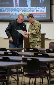 Gary Cox, commissioner of the Oklahoma State Department of Health discusses information with Brig. Gen. Tommy Mancino, commander of the Oklahoma National Guard Joint Task Force, at the Joint Task Force’s headquarters in Oklahoma City, March 20, 2020. The OKNG Joint Task Force was activated to help the OKNG support a whole-of-Oklahoma-government response to the COVID-19 pandemic. (Oklahoma National Guard Photo by Sgt. Anthony Jones)