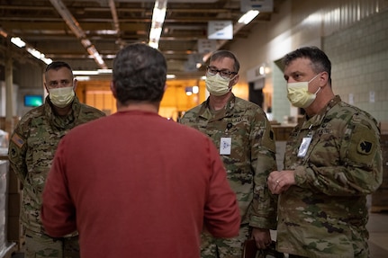 Leaders from the Oklahoma National Guard — including (left to right) Lt. Col. Clint Carman, Oklahoma Joint Task Force operations officer; Col. Robert Henry Walter Jr., Oklahoma Joint Task Force commander; and Brig. Gen. Tommy Mancino, commander of the Governor’s Solution Task Force — speak with an employee from Oklahoma’s Strategic National Stockpile while visiting the stockpile in Oklahoma City, April 14, 2020. The nearly 30 Guardsmen assigned to the site — partnered with state agency partners like the Oklahoma Department of Emergency Management, Oklahoma Department of Public Safety, Oklahoma Department of Transportation, Oklahoma Office of Homeland Security and the Oklahoma Department of Corrections — help fulfill, secure and transport the orders from facilities within the 11 identified COVID-19 regional health administration locations throughout Oklahoma as part of the state’s whole-of-government response to the pandemic. (U.S. Air National Guard photo by Tech. Sgt. Kasey Phipps)