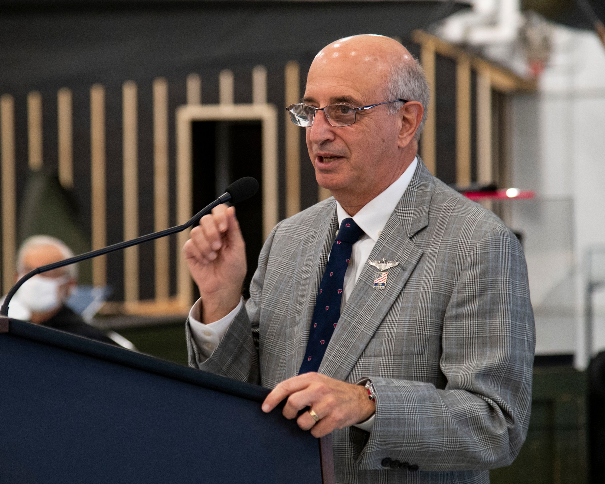 Ralph Galati, former prisoner of war, addresses attendees after the unveiling of the Chair of Honor display at the Air Mobility Command Museum on Dover Air Force Base, Delaware, Nov. 11, 2021. The aircraft chair is one of 58 dedicated chairs of honor throughout the state of Delaware and the first aircraft chair. (U.S. Air Force photo by Roland Balik)