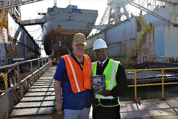 The Hon. Rupert Soames, OBE, and Cmdr. Brian Anthony, USS Winston S. Churchill commanding officer, exchange gifts upon the conclusion of the tour of the Arleigh Burke-class destroyer.