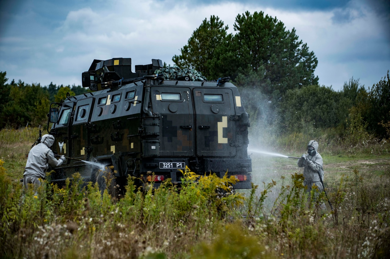 Soldiers decontaminate a vehicle.