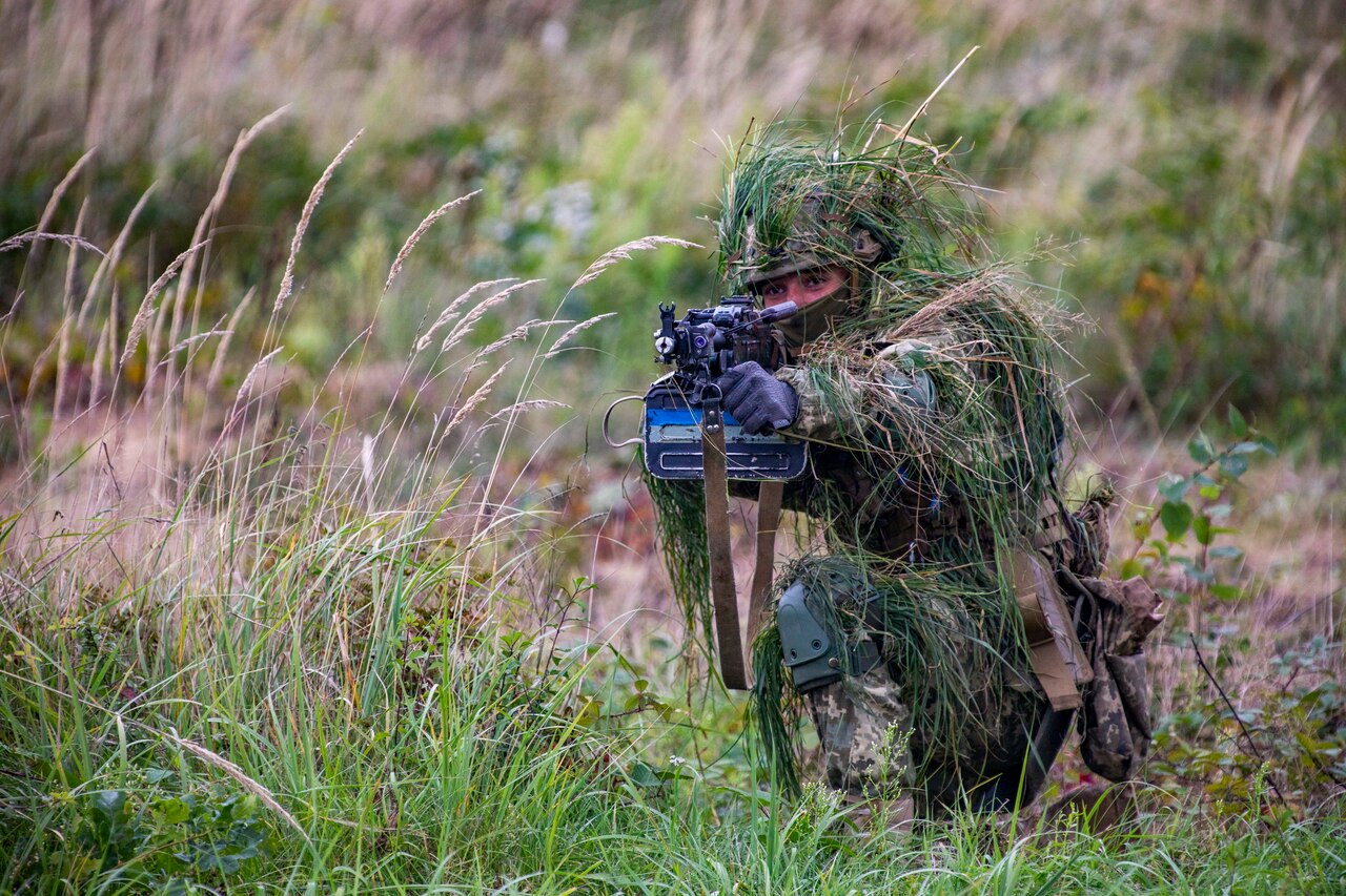 A soldier aims his weapon