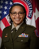 woman in army uniform standing in front of flags