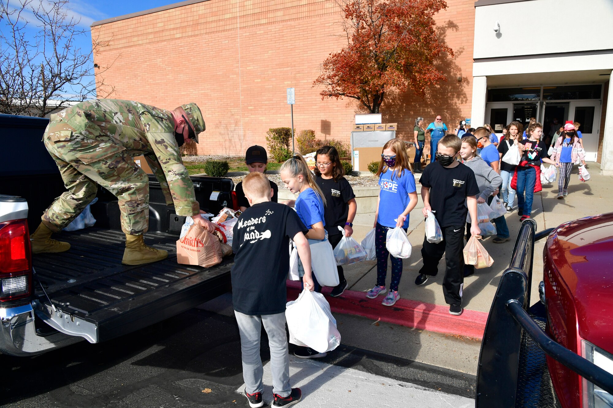 Master Sgt. Randy Hassenplug, 75th Force Support Squadron first sergeant, loads food items into a truck with the help of students.