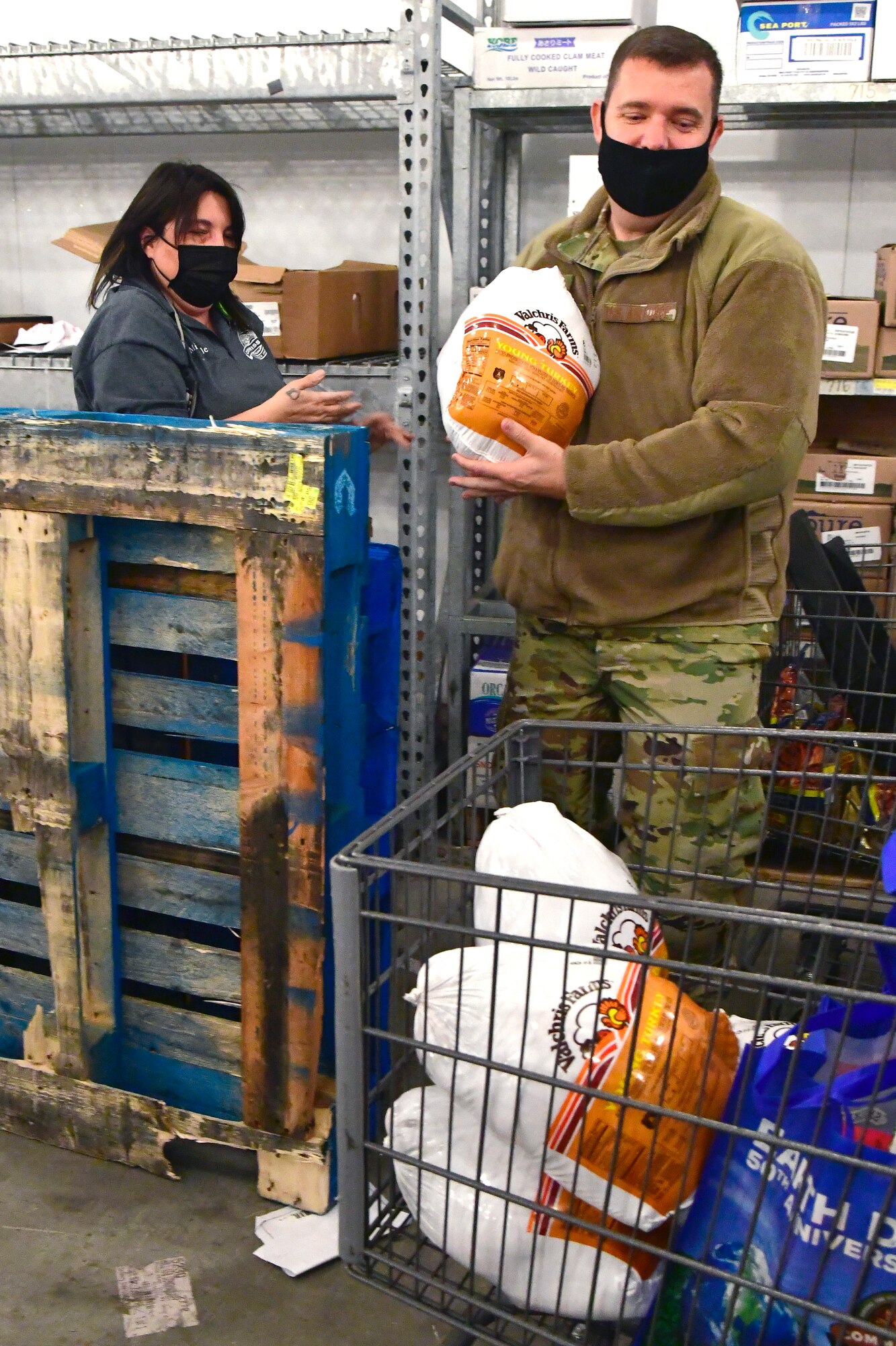 Michele Bolin (left), Commissary employee, hands over a turkey to Senior Master Sgt. Shaun Comley, 388th Maintenance Squadron first sergeant.