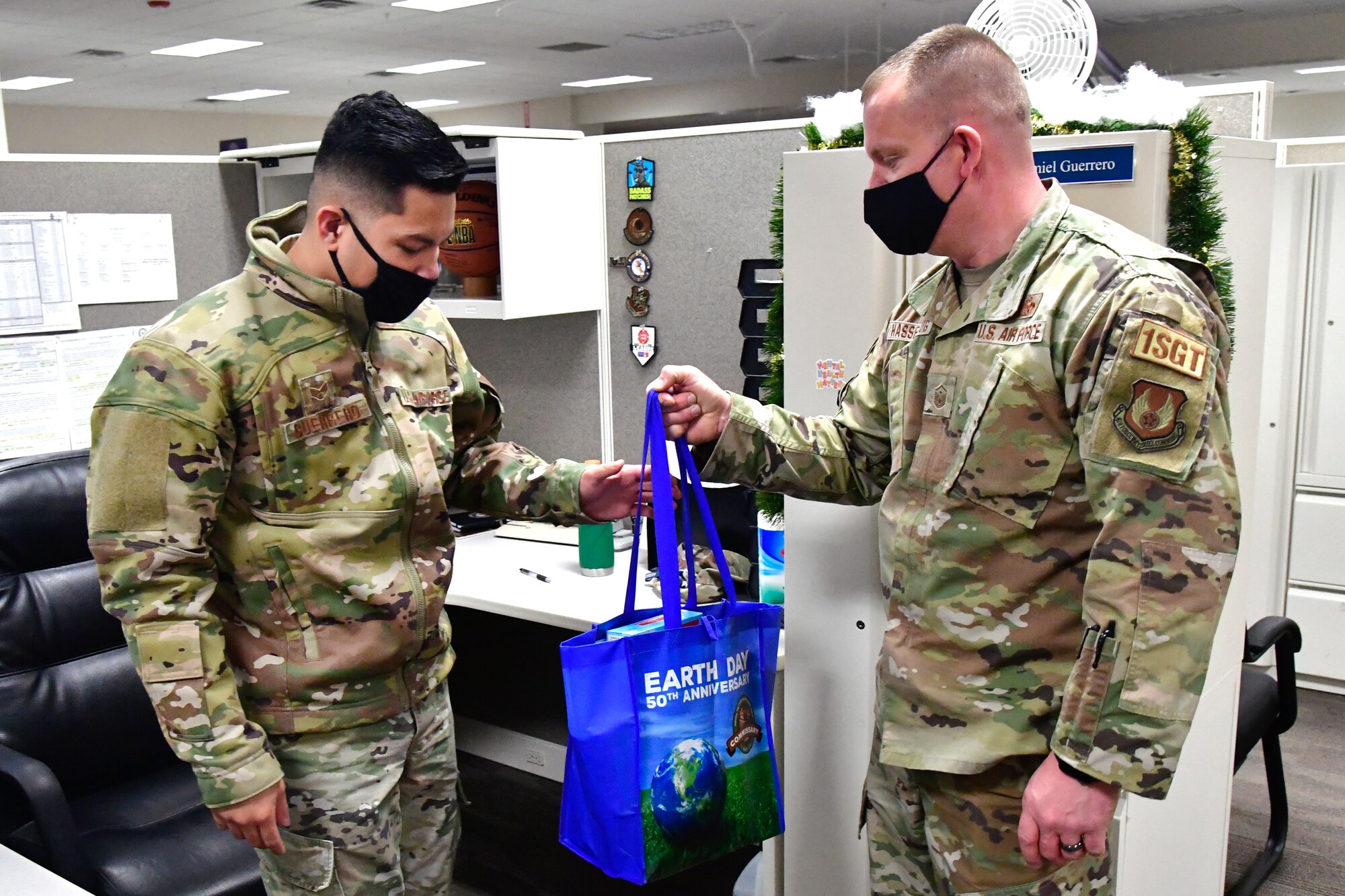 Senior Airman Amiel Guerrero, 75th Force Support Squadron, receives a Thanksgiving meal kit from Master Sgt. Randy Hassenplug, 75th Force Support Squadron first sergeant.