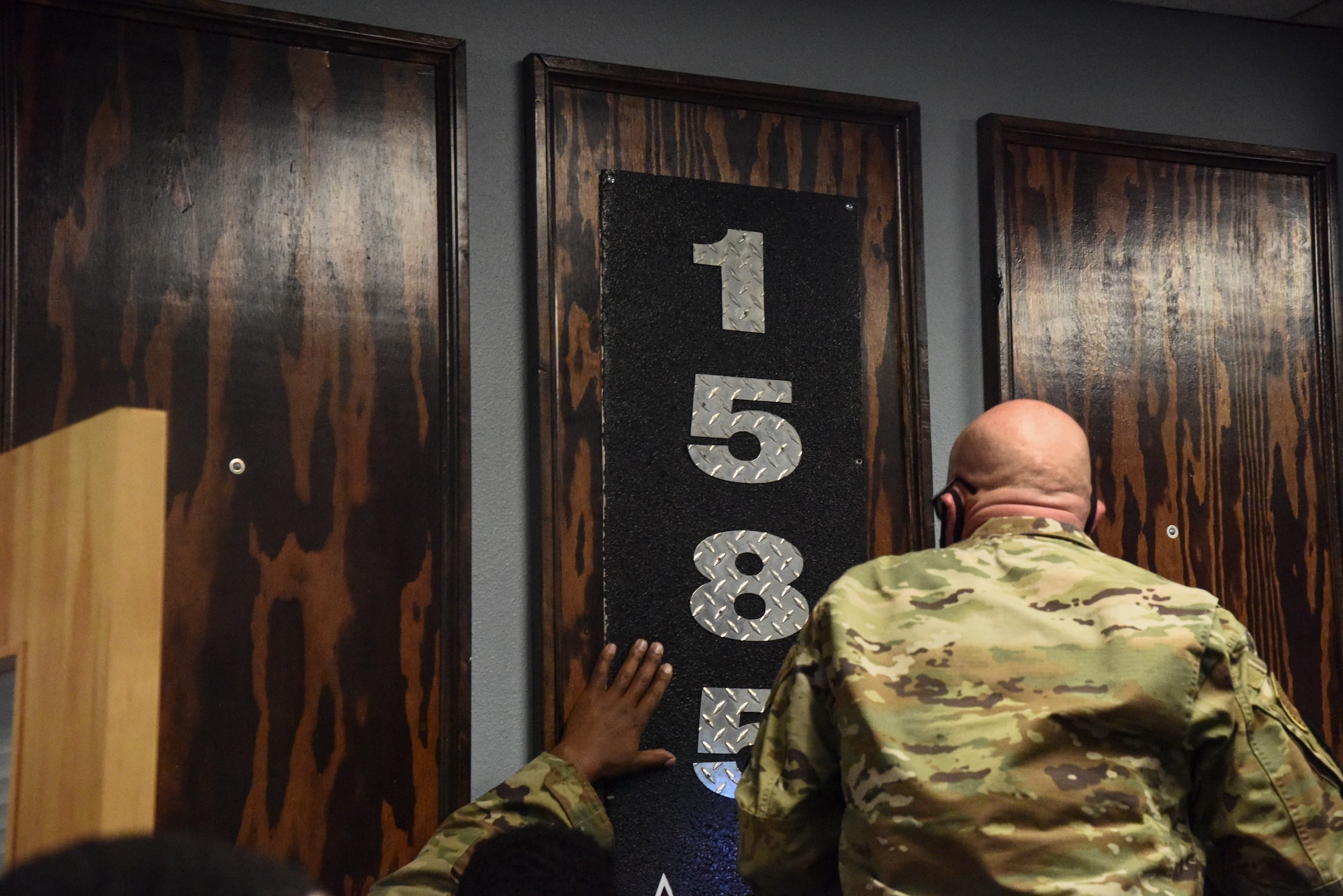 Pictured above is a man placing a steel plaque to a wooden board.