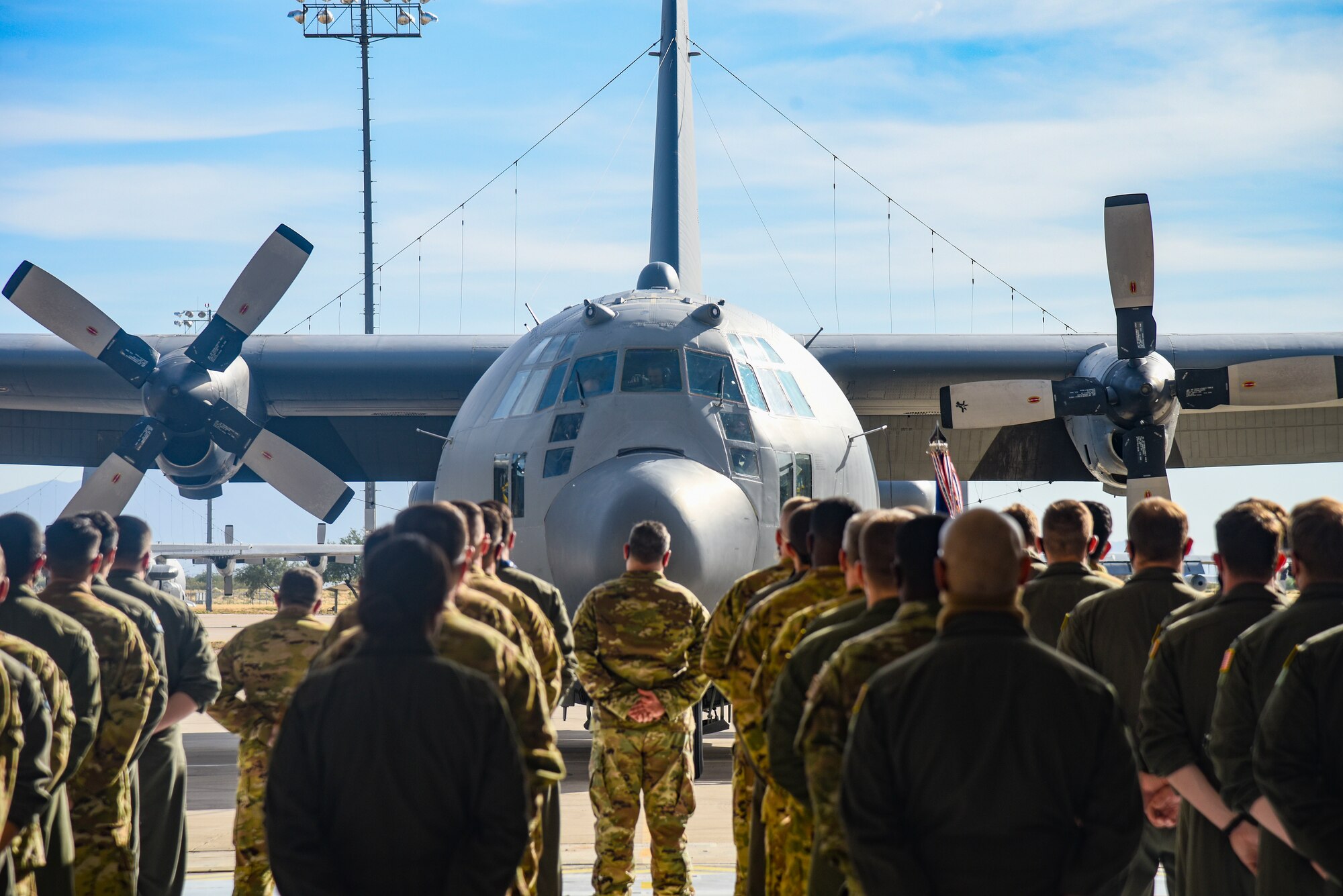 Pictured above is a group of people standing in front of a parked aircraft.