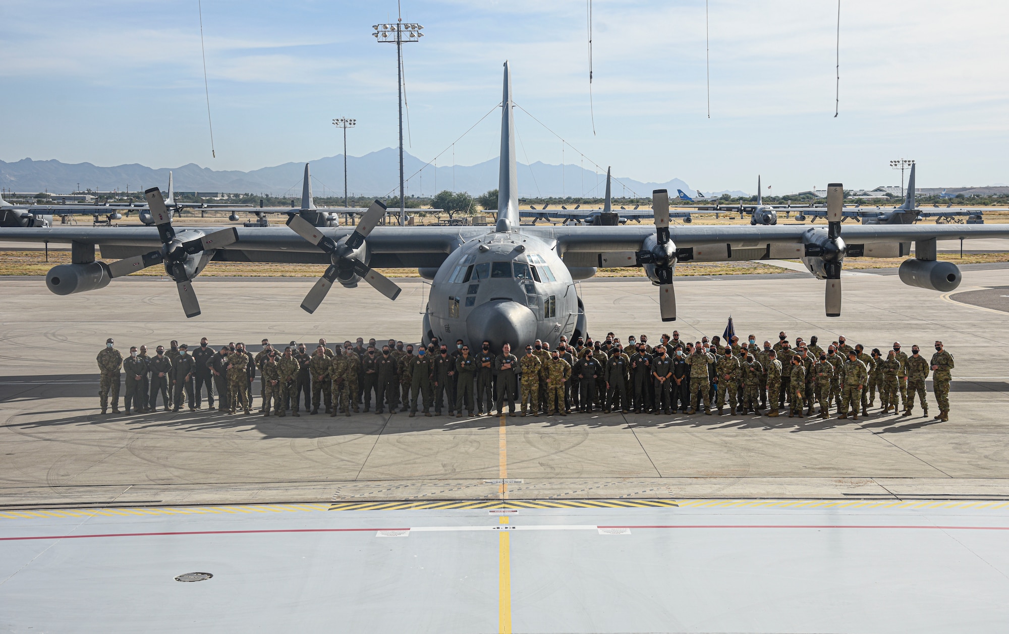 Pictured above is a group of people posing for a photo in front of an aircraft.