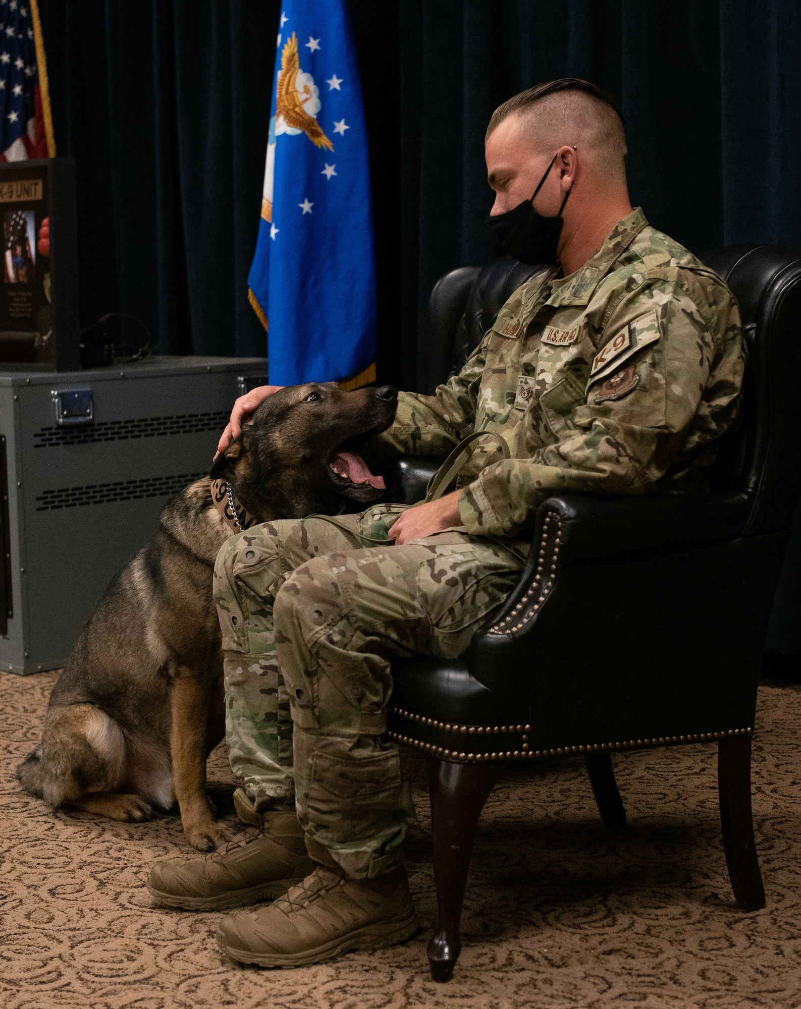 Military Working Dog Fulda W378, 27th Special Operations Security Forces Squadron K-9, looks at his handler and adopter U.S. Staff Sgt. Michael Herman, 27 SOSFS K-9 handler, during Fulda’s retirement ceremony at Cannon AFB, N.M., Nov 16, 2021. MWD Fulda served 7 years in the U.S. Air Force, most recently with Herman, who has adopted him and will take care of Fulda for the rest of his days. (U.S. Air Force photo by Senior Airman Christopher Storer)