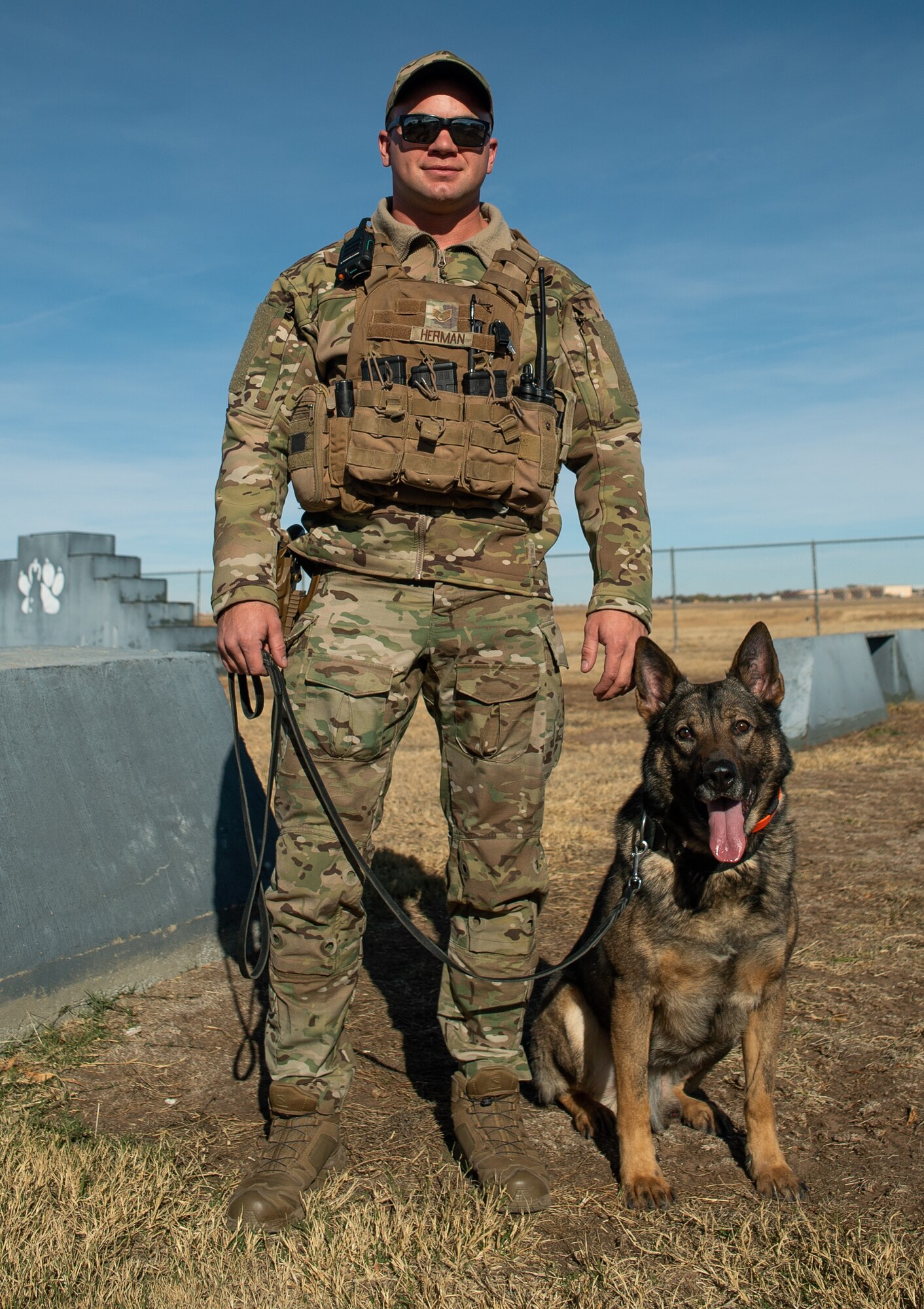 Military Working Dog Fulda W378, 27th Special Operations Security Forces Squadron K-9, stands with his handler and adopter U.S. Air Force Staff Sgt. Michael Herman, 27 SOSFS K-9 handler, at the K-9 training grounds on Cannon AFB, N.M., Nov. 15, 2021. MWD Fulda spent 7 years sniffing and searching for explosive materials to ensure the safety of service members worldwide. (U.S. Air Force photo by Senior Airman Christopher Storer)
