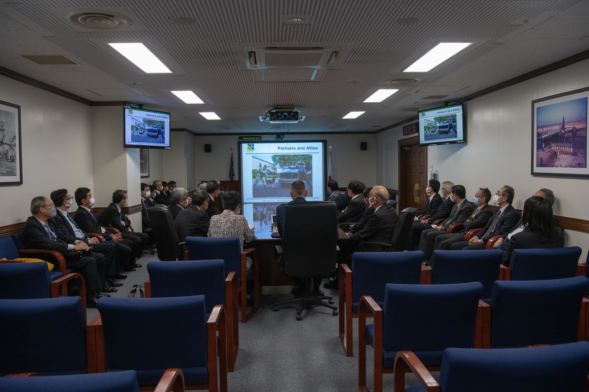 Mitsuru Takahashi, 374th Airlift Wing Public Affairs community relations specialist, translates for Col. Andrew Campbell, 374th Airlift Wing commander, during a briefing held for Japanese mayors from the Kanto, Tohoku, and Hokkaido regions, who toured Yokota Air Base, Japan, Nov. 15, 2021. Campbell emphasized the importance of the U.S.-Japan alliance to achieving a free and open Indo-Pacific region. (U.S. Air Force photo by Airman 1st Class Brooklyn Golightly)