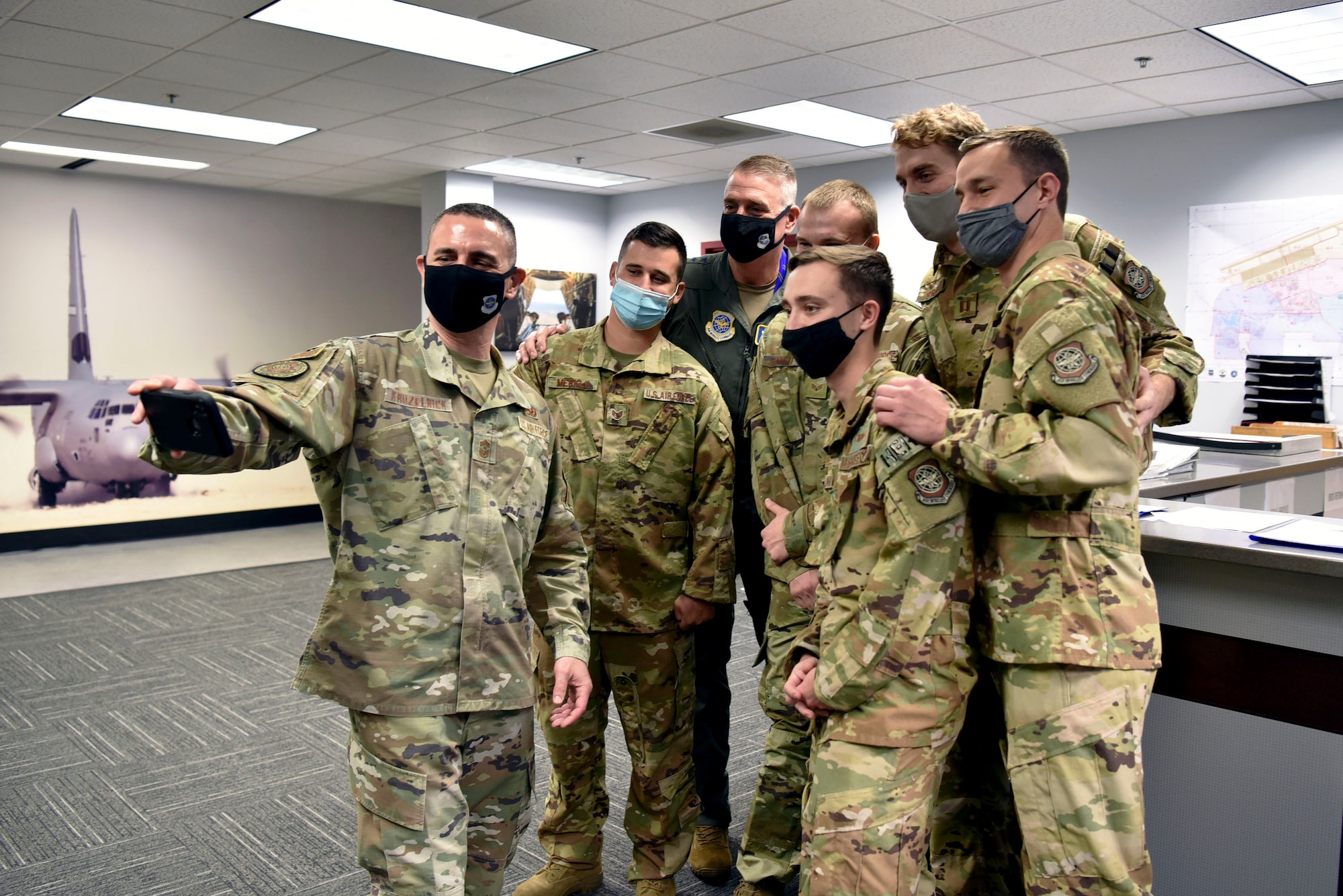 Airmen take a photo with the AMC commander and command chief.