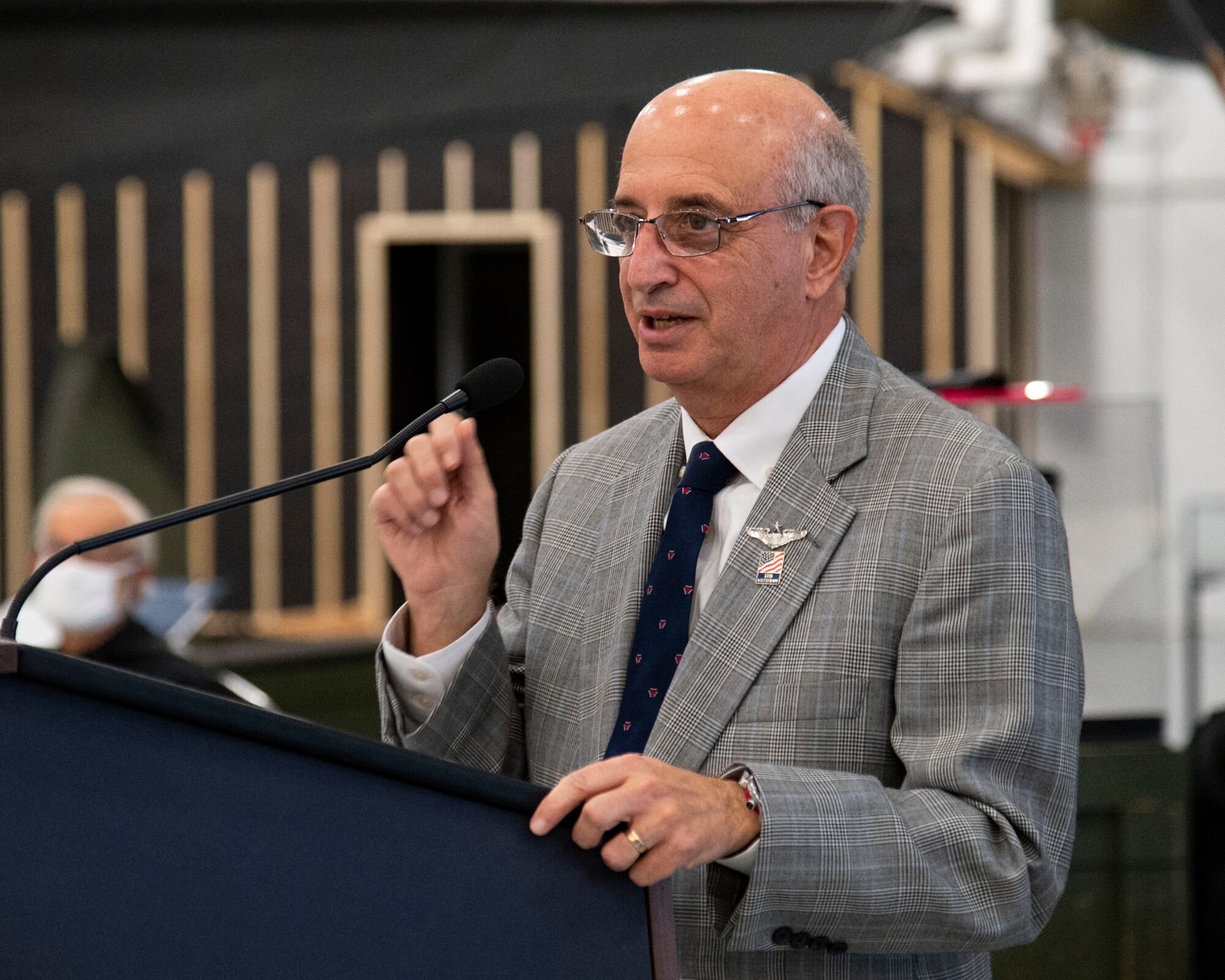 Ralph Galati, former prisoner of war, addresses attendees after the unveiling of the Chair of Honor display at the Air Mobility Command Museum on Dover Air Force Base, Delaware, Nov. 11, 2021. The aircraft chair is one of 58 dedicated chairs of honor throughout the state of Delaware and the first aircraft chair. (U.S. Air Force photo by Roland Balik)