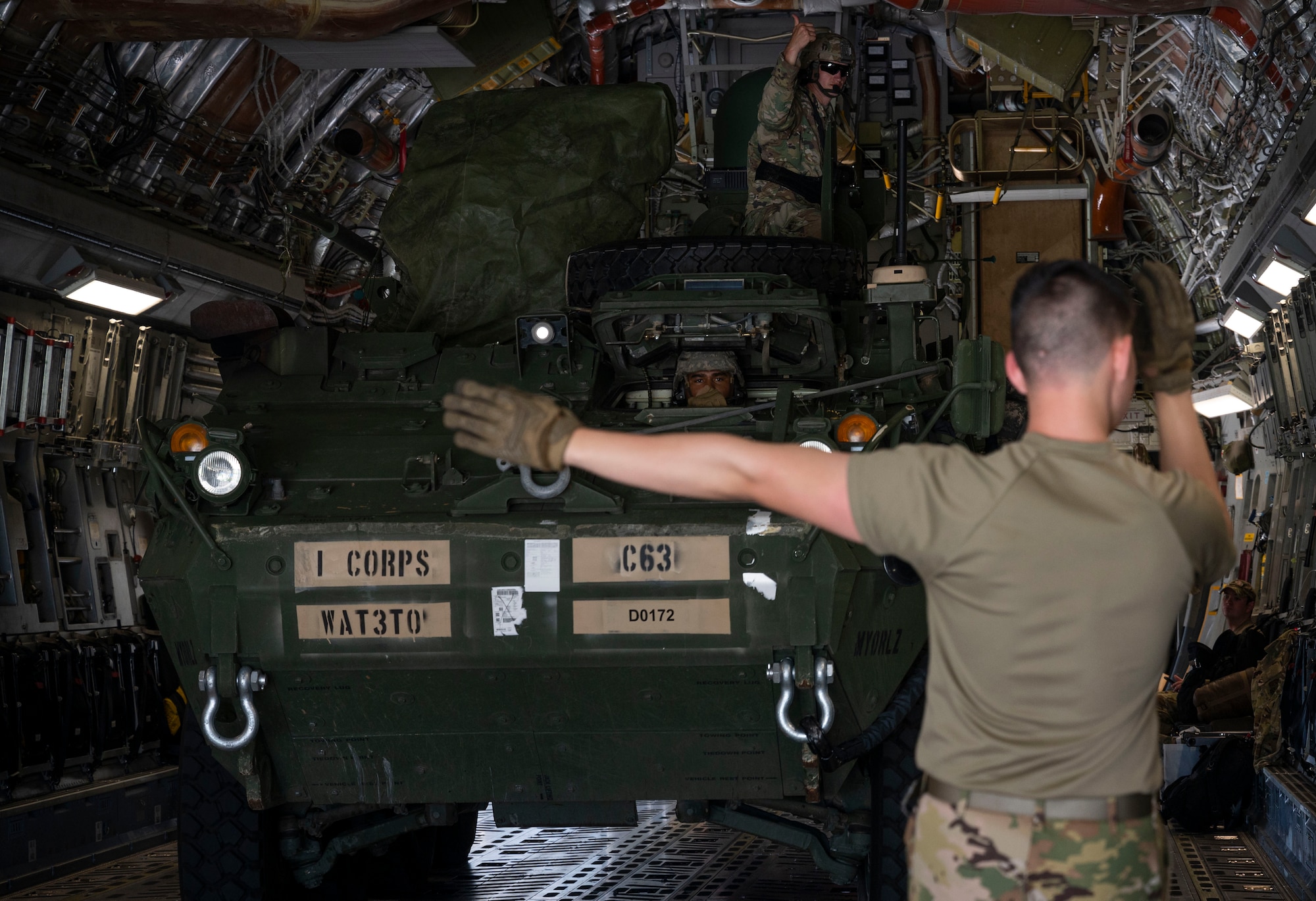 U.S. Air Force Airman 1st Class Aydan Abad, a loadmaster with the 7th Airlift Squadron, marshals an U.S. Army Stryker onto a C-17 Globemaster III during Exercise Rainier War 21B at Andersen Air Force Base, Guam, Nov. 9, 2021. Rainier War 21B exercised and evaluated the 62nd Airlift Wing’s ability to employ the force and their ability to perform during wartime and contingency taskings in a high-intensity, wartime contested, degraded and operationally limited environment while supporting the contingency operations against a near-peer adversary in the U.S. Indo-Pacific Command area of responsibility. (U.S. Air Force photo by Staff Sgt. Rachel Williams)