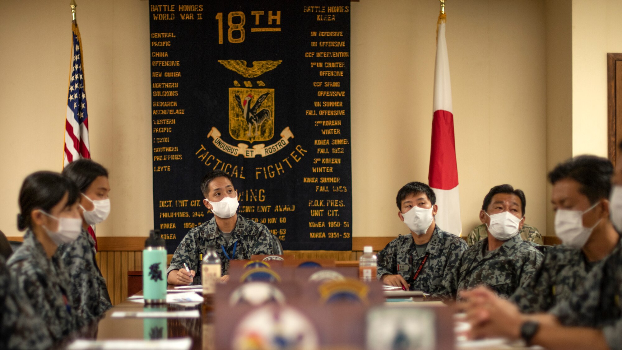 Japan Air Self-Defense Force members discuss multi-capable Airmen during a briefing at Kadena Air Base, Japan, Nov. 10, 2021. Multi-capable Airmen train as a cross functional team to meet and provide combat support to aviation forces conducting dispersed and dynamic operations. (U.S. Air Force photo by Senior Airman Jessi Monte)