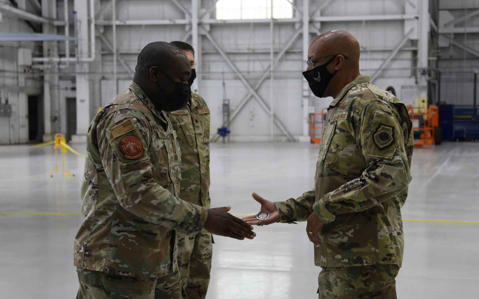 Air Force Chief of Staff Gen. CQ Brown, Jr. (right), presents a challenge coin to Master Sgt. Alfred McDuffie, 459th Air Refueling Squadron NCO in-charge of mobility operations, at Joint Base Andrews, Md., Nov. 17, 2021. During his visit, Brown coined multiple Airmen for their superior performances in their work centers and their contributions to the Air Force mission. (U.S. Air Force photo by Senior Airman Spencer Slocum)