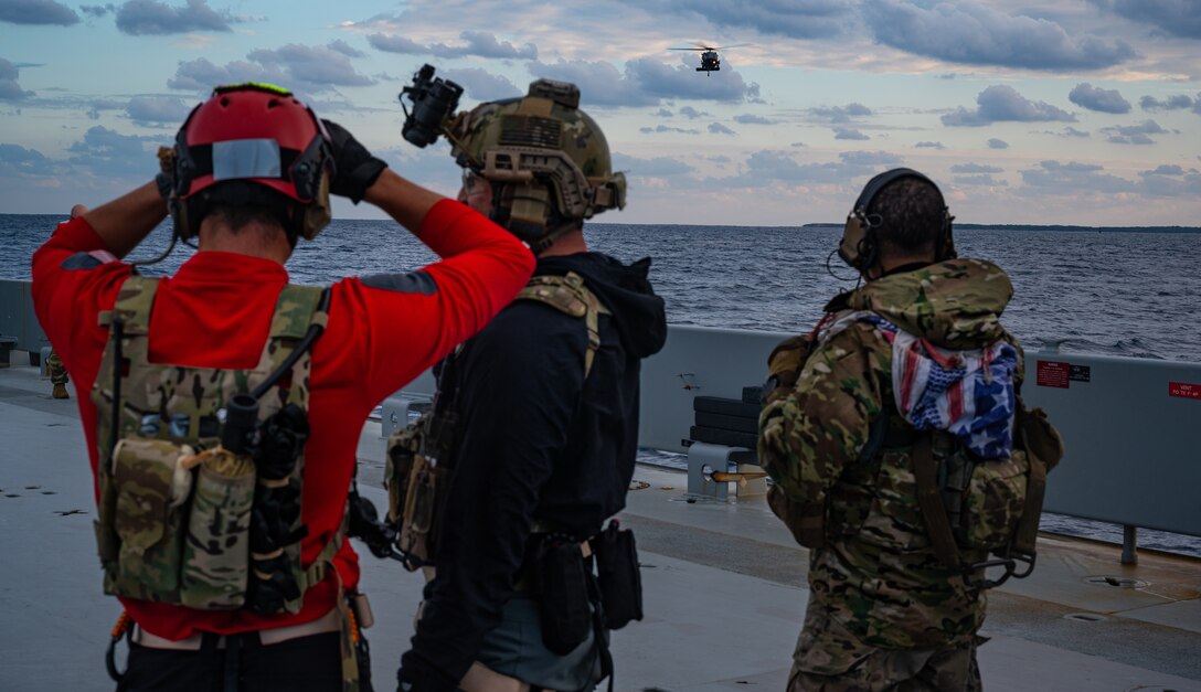 Airmen watch helicopter.