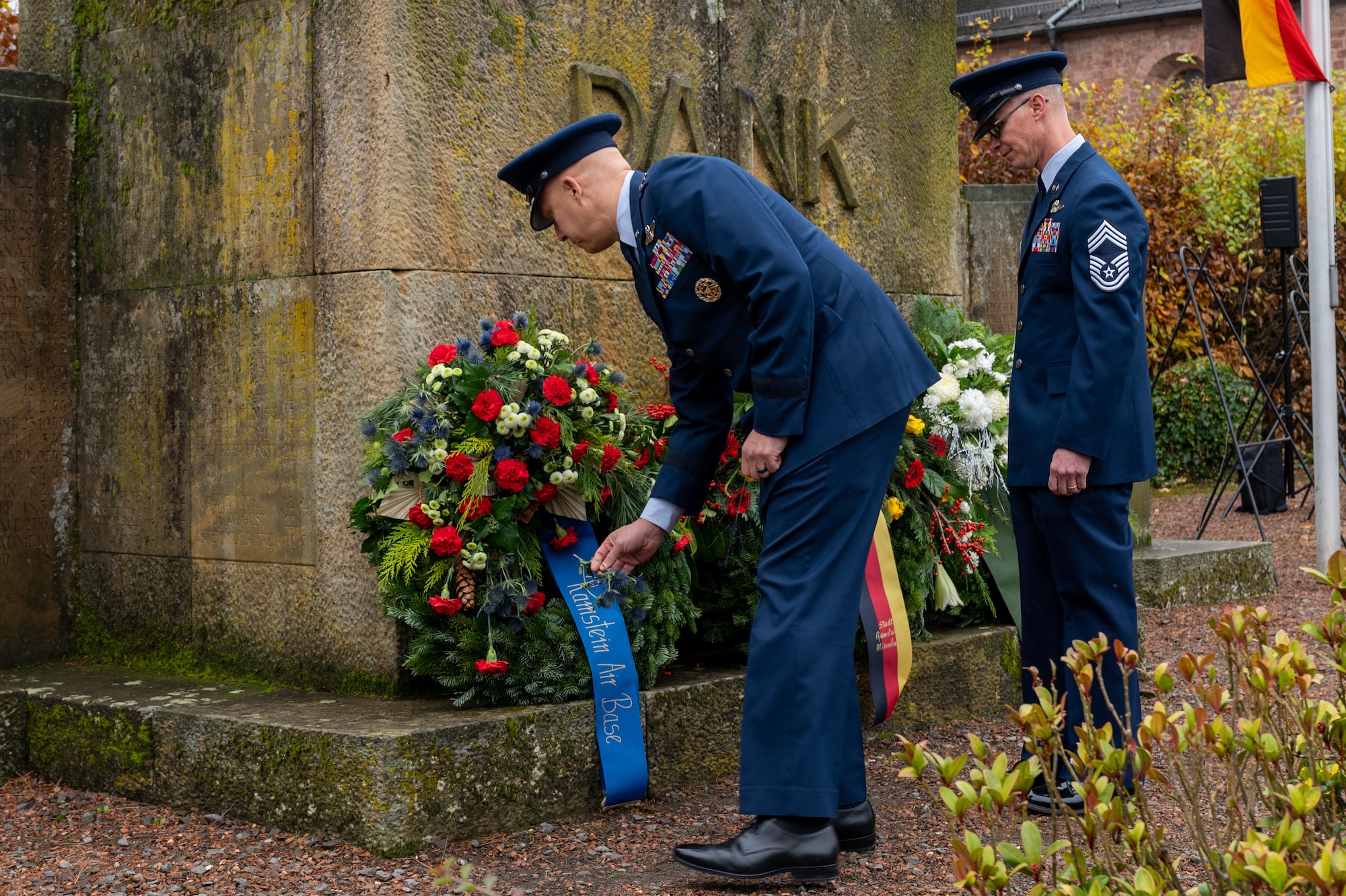 Two military members standing next to a monument.