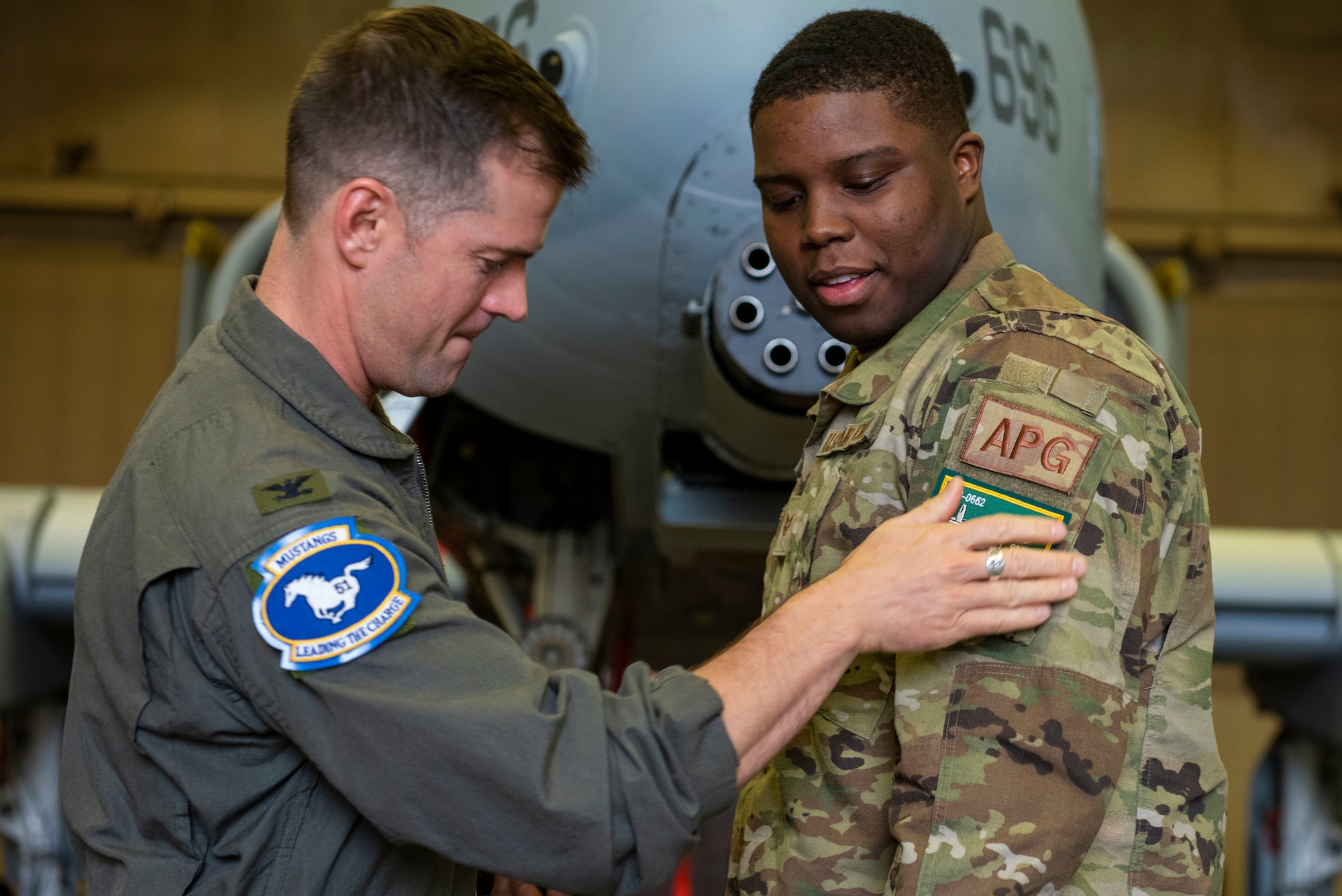 Col. Joshua “Dog” Wood, 51st Fighter Wing commander, applies a dedicated crew chief patch to Staff Sgt. Alijah Smith, 51st Aircraft Maintenance Squadron dedicated crew chief