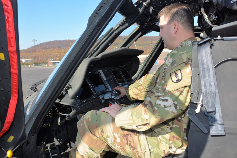 Chief Warrant Officer 4 Frank Madeira, an instructor pilot at the Eastern Army National Guard Aviation Training Site, points out a feature of a UH-60V Black Hawk helicopter on Muir Army Airfield at Fort Indiantown Gap, Pa., on Nov. 10, 2021.
