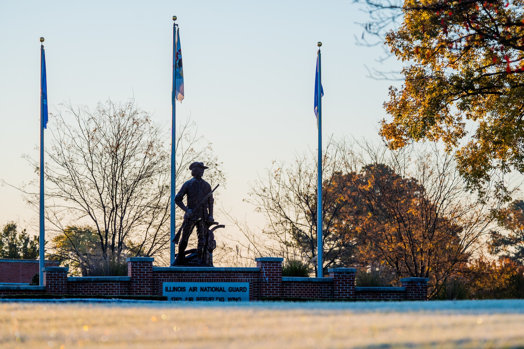 A minute man statue stands on a sign 126th Air Refueling Wing  sign with a brick façade..