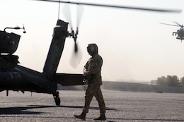 Soldier and Apache helicopter