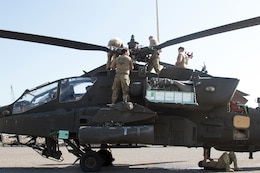 Soldiers work on an Apache helicopter