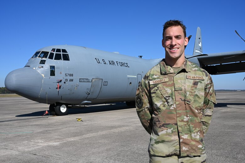 An Airman stands in front of a plane.