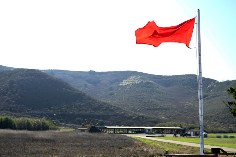 A red live-fire flag flaps in the wind at the 30th Security Forces Squadron Combat Arms Training and Maintenance section building on Nov. 5, 2021 at Vandenberg Space Force Base, Calif. The 30th SFS provides reoccurring and deployment-ready weapons qualification training to hundreds of Vandenberg personnel each year. (U.S. Space Force photo by Staff Sergeant Draeke Layman)