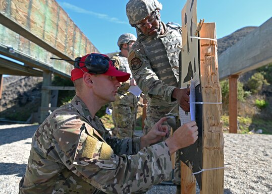 Senior Airman William Boyce, 30th Security Forces Squadron combat arms instructor reviews a member’s shot grouping during a live-fire training at the Combat Arms Training and Maintenance range on Nov. 5, 2021 at Vandenberg Space Force Base, Calif. The 30th SFS provides reoccurring and deployment-ready weapons qualification training to hundreds of Vandenberg personnel each year. (U.S. Space Force photo by Staff Sergeant Draeke Layman)