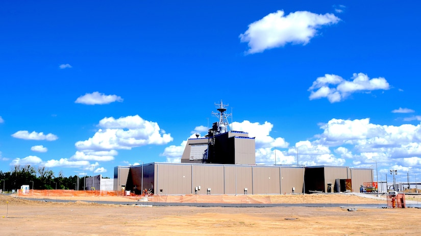 A military complex stands under a dark blue sky.