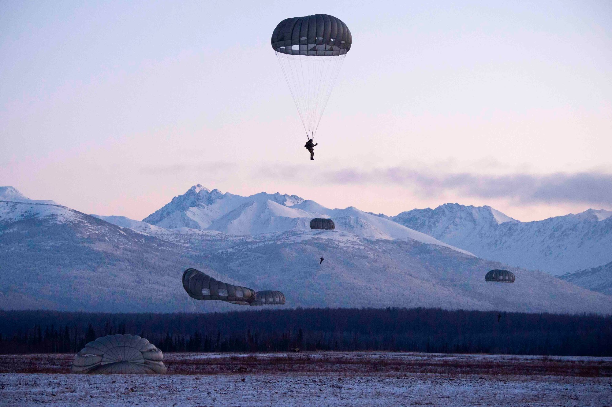 Tactical air control party specialists descend after jumping from a U.S. Army CH-47F Chinook