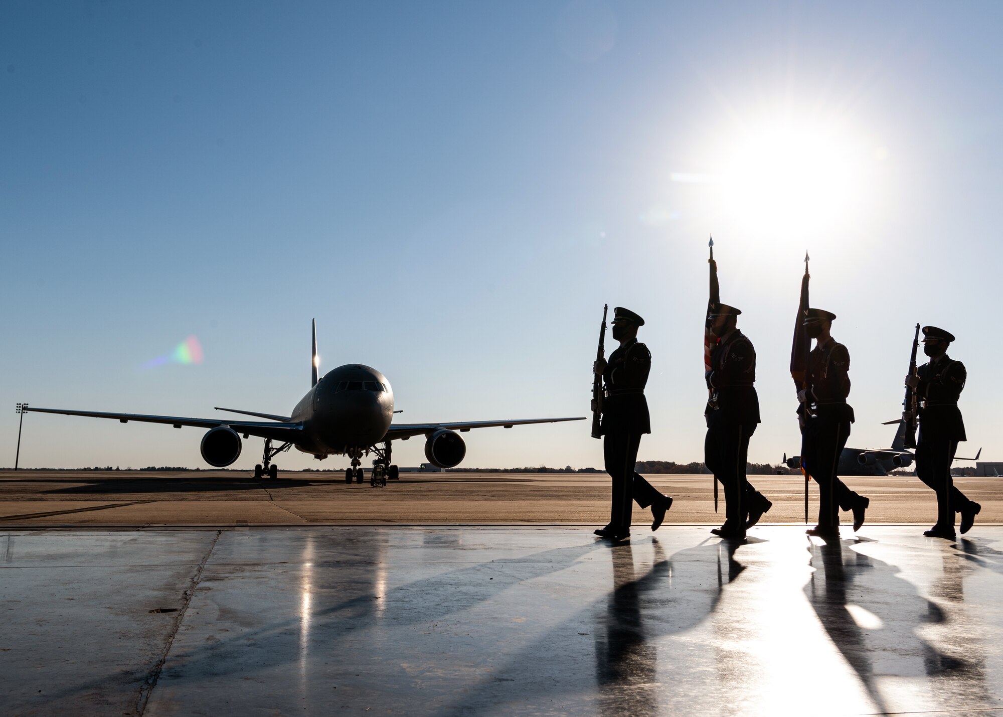 The joint base honor guard marches past a KC-46A Pegasus as part of a welcome ceremony at Joint Base McGuire-Dix-Lakehurst