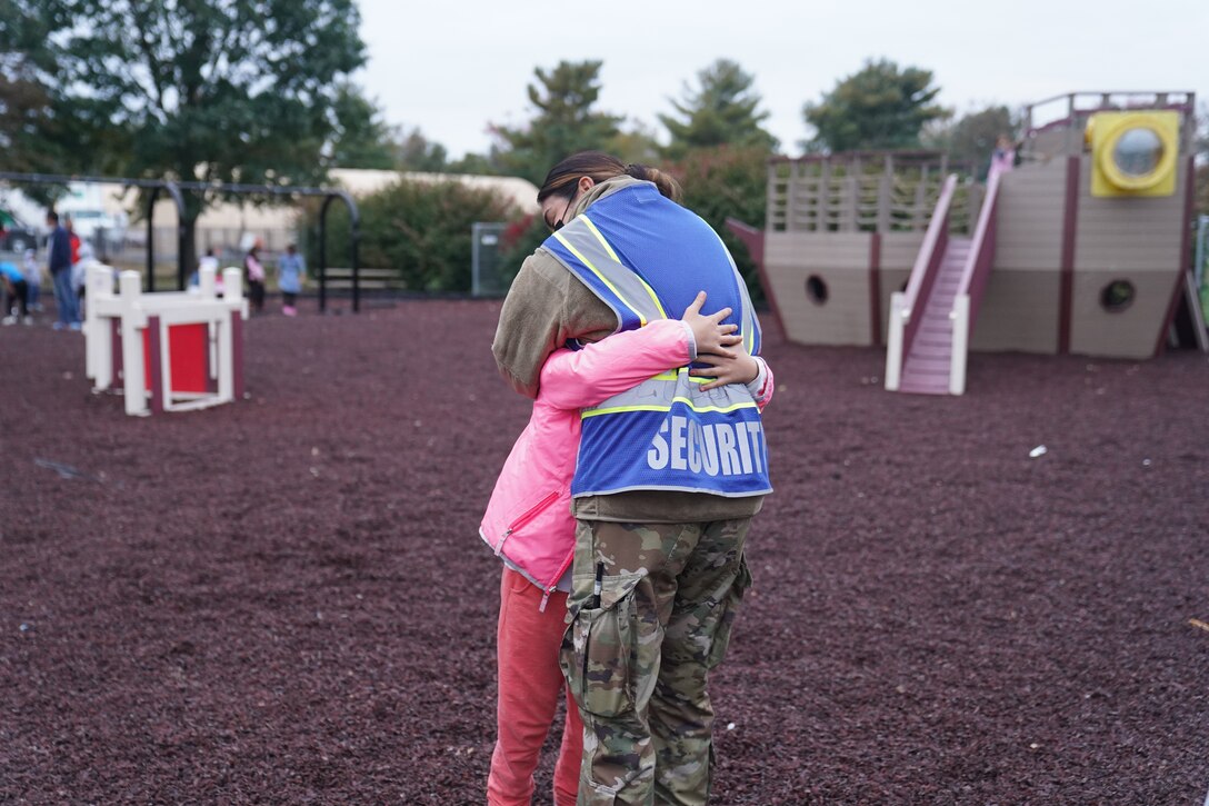 A service member assigned to Task Force Liberty embraces an Afghan child at a park at Liberty Village as she supports Operation Allies Welcome on Joint Base McGuire-Dix-Lakehurst, New Jersey, Oct. 28, 2021. The Department of Defense, through U.S. Northern Command, and in support of the Department of Homeland Security, is providing transportation, temporary housing, medical screening and general support for at least 50,000 Afghan evacuees at suitable facilities in permanent or temporary structures as quickly as possible. This initiative provides Afghan personnel essential support at secure locations outside of Afghanistan. (U.S. Air National Guard photo by Lt. Col. Candis Olmstead)