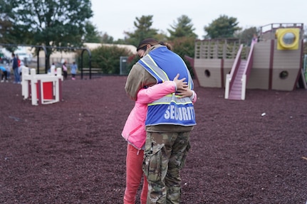 A service member assigned to Task Force Liberty embraces an Afghan child at a park at Liberty Village as she supports Operation Allies Welcome on Joint Base McGuire-Dix-Lakehurst, New Jersey, Oct. 28, 2021. The Department of Defense, through U.S. Northern Command, and in support of the Department of Homeland Security, is providing transportation, temporary housing, medical screening and general support for at least 50,000 Afghan evacuees at suitable facilities in permanent or temporary structures as quickly as possible. This initiative provides Afghan personnel essential support at secure locations outside of Afghanistan. (U.S. Air National Guard photo by Lt. Col. Candis Olmstead)