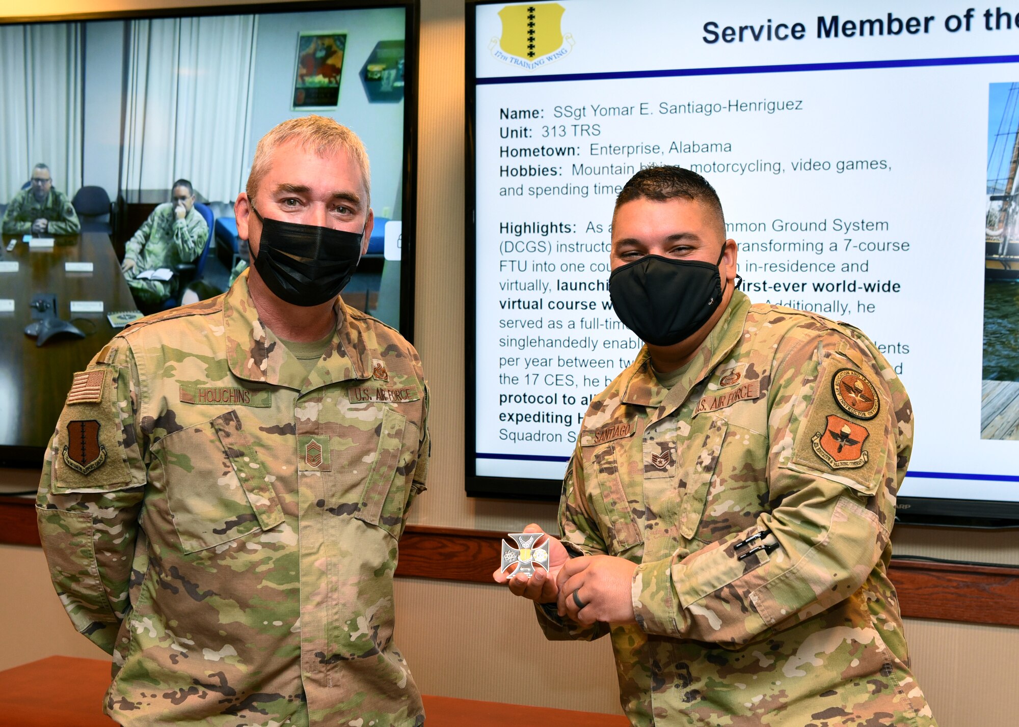 U.S. Air Force Chief Master Sgt. Craig Houchins, 17th Mission Support Group command chief and Staff Sgt. Yomar Santiago-Henriguez, 313th Training Squadron Distributed Common Ground System course instructor, pose for a photo on Goodfellow Air force Base, Texas, Nov. 16, 2021. Santiago-Henriguez was coined for his outstanding performance as an instructor and efforts leading to the heating, ventilation and air conditioning repairs inside a sensitive compartmented information facility.  (U.S. Air Force photo by Senior Airman Abbey Rieves)