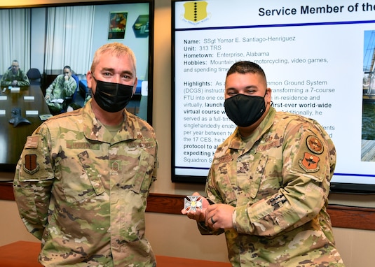 U.S. Air Force Chief Master Sgt. Craig Houchins, 17th Mission Support Group command chief and Staff Sgt. Yomar Santiago-Henriguez, 313th Training Squadron Distributed Common Ground System course instructor, pose for a photo on Goodfellow Air force Base, Texas, Nov. 16, 2021. Santiago-Henriguez was coined for his outstanding performance as an instructor and efforts leading to the heating, ventilation and air conditioning repairs inside a sensitive compartmented information facility.  (U.S. Air Force photo by Senior Airman Abbey Rieves)