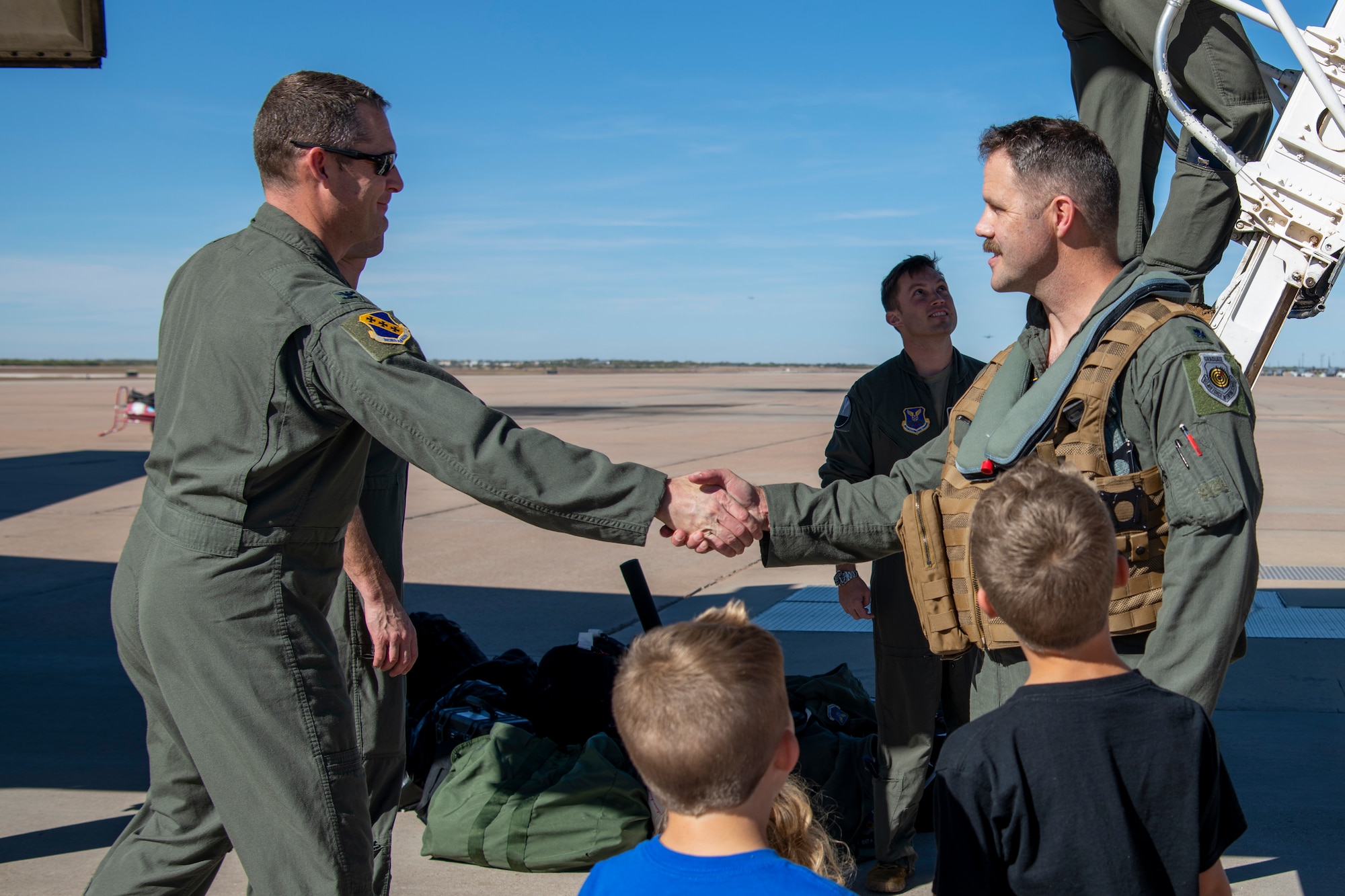 Col. Joseph Kramer, 7th Bomb Wing commander, left, shakes hands with Lt. Col. Brian Boland, 345th Bomb Squadron pilot, after he returned to Dyess Air Force Base, Texas, Nov. 15, 2021, from a Bomber Task Force Europe deployment.