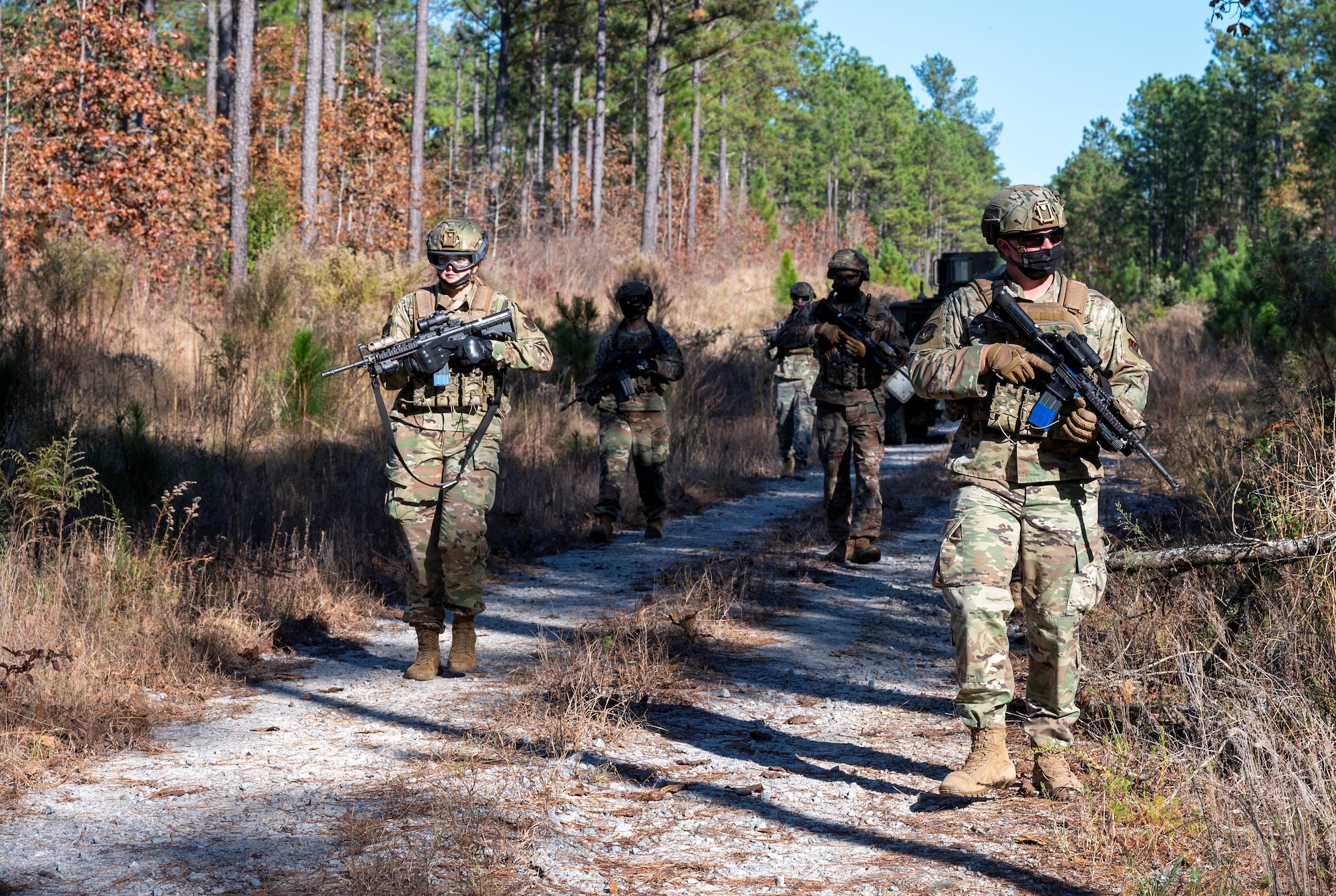 A photo of airmen walking down a dirt path.